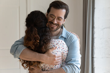 Happy young couple man and woman hug cuddle make peace reconcile after family fight. Smiling...