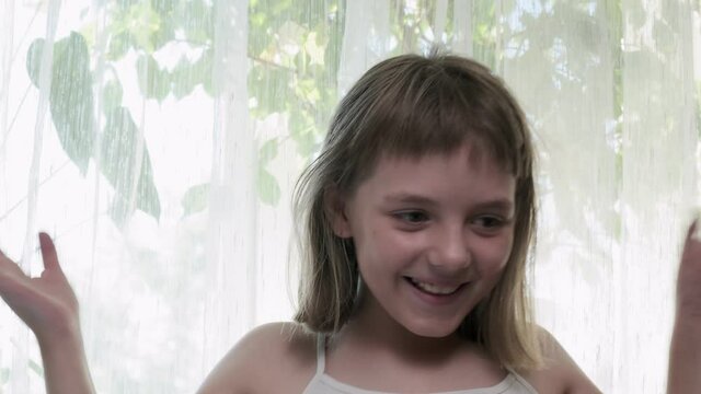Little eight-year-old caucasian girl grimaces in front of camera. Mind blown reaction of little girl expressing her shock of something unbelievable. excited girl showing gesture of brain explosion