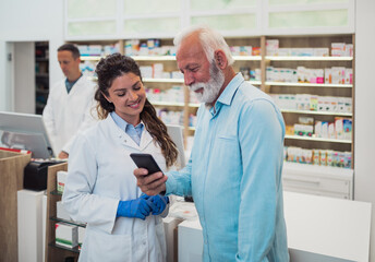 Obraz premium Professional pharmacist working with customers in modern drugstore.