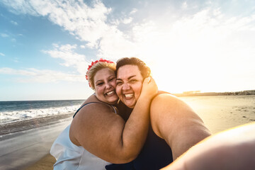 Happy plus size women taking selfie on the beach - Curvy overweight girls having fun during vacation in tropical destination - Over size confident people lifestyle concept