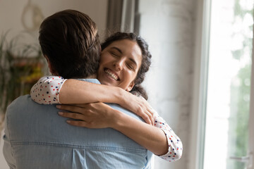 Overjoyed young Caucasian woman hug man husband showing love and care, make peace after fight....