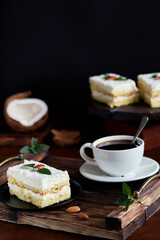 Raffaello coconut cake garnished with mint and almonds on a dark background
