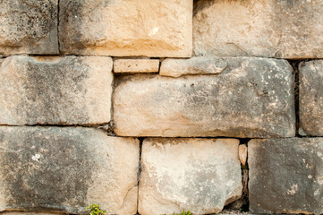 Big stones sandstone ancient dry masonry wall closeup as stone background