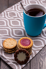 cookies with different fillings and a Cup of tea on a wooden table