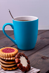 cookies with different fillings and a Cup of tea on a wooden table
