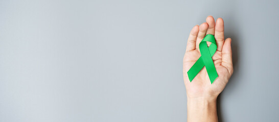 Man holding green Ribbon for supporting people living and illness. Liver, Gallbladders bile duct,...