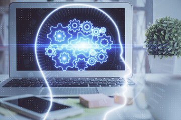 Double exposure of work space with computer and human brain drawing hologram. Brainstorm concept.