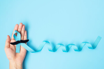November Prostate Cancer Awareness month, adult Man holding light Blue Ribbon with mustache for...