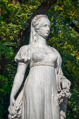 Fototapeta premium Monument of Queen Luisen in the Scholl Park Siblings (Geschwister Scholl Park) in Autumn colors in historical downtown in Magdeburg, Germany..