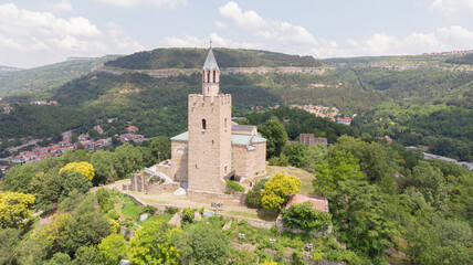 Fototapeta na wymiar Old Balkan fortress on Bulgaria, world heritage in Veliko Tarnovo. Historical structure medieval castle on a hill. Drone aerial view of sightseeing monument landmark. Cultural Stronghold