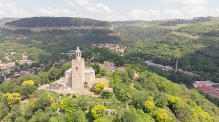Fototapeta premium Old Balkan fortress on Bulgaria, world heritage in Veliko Tarnovo. Historical structure medieval castle on a hill. Drone aerial view of sightseeing monument landmark. Cultural Stronghold