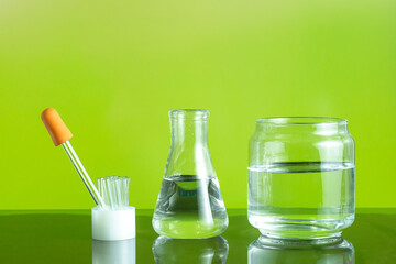 Assorted empty laboratory glassware, test-tubes. Green tone medical background. Copy space
