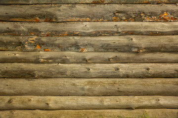 Background looks like a fragment of wall of round wooden logs. Detail of architecture and building structures.