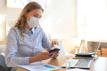 Woman using sanitizer hand gel. Cleaning smartphone by sanitizer. Coronavirus protection.