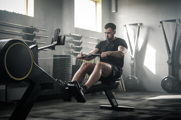 Handsome Man Has Arms Workout On Rowing Machine . - 381094296