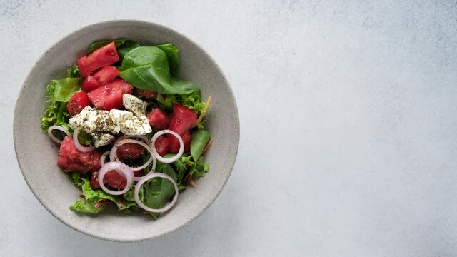 Serving greek salad in bowl, top view with copy space