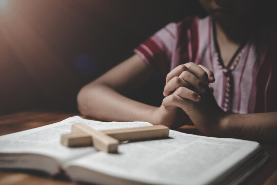 Religious Christian boy praying over Bible indoors