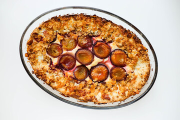 Homemade Ricotta Plum Cake on a white table. Cottage cheese casserole with vanilla, semolina and plums.