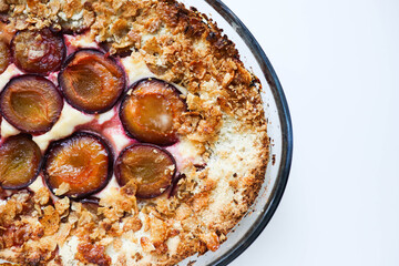 Homemade Ricotta Plum Cake on a white table. Cottage cheese casserole with vanilla, semolina and plums.