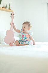 Baby girl playing ukulele
