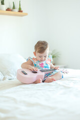 Baby girl playing ukulele