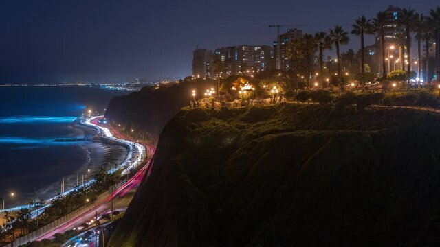 El Parque del Amor or Love park day to night transition timelapse in Miraflores after sunset, Lima, Peru. The Kiss statue with people sitting and walking around. Coastline with cliffs