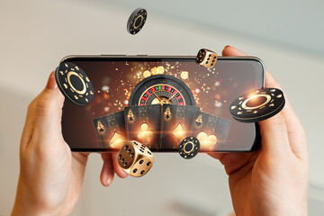 Creative background, online casino, in a man's hand a smartphone with playing cards, roulette and chips, black-gold background. Internet gambling concept. Copy space - obrazy, fototapety, plakaty
