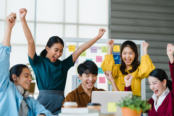 Group of Asia young creative people in smart casual wear discussing business celebrate giving five...