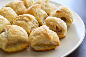 Sausage roll savoury pastry snack on a white plate.