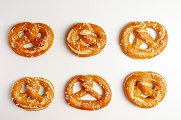 Different tasty homemade pretzels on white background