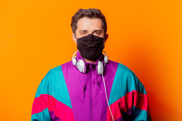 Style man in face mask and 80s tracksuit with headphones