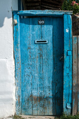 Old wooden grunge blue rural house door closeup in sunny day