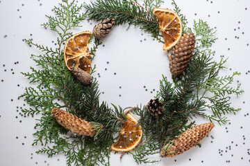 wreath of spruce and thuja branches, cones and orange slices
