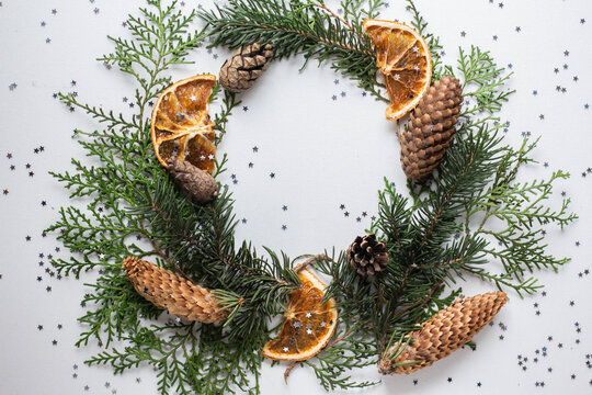 wreath of spruce and thuja branches, cones and orange slices