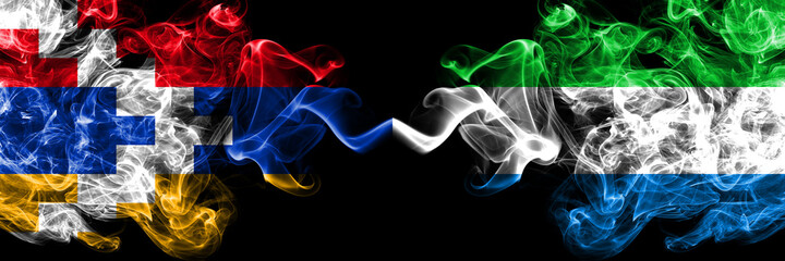 Nagorno-Karabakh, Artsakh vs Sierra Leone smoky mystic flags placed side by side. Thick colored silky abstract smoke flags