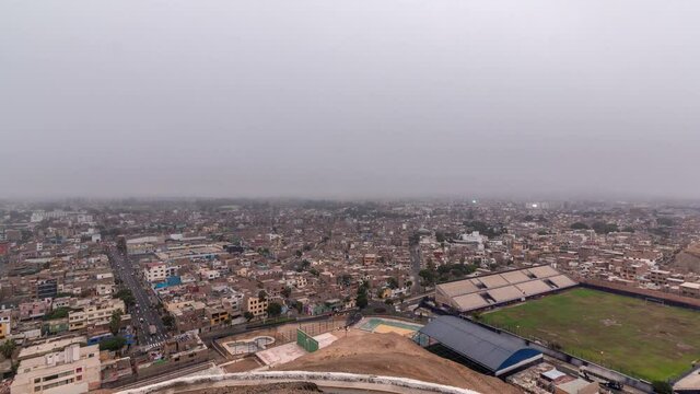 Panoramic skyline of Lima city from above with many buildings aerial night to day transition timelapse from hill. Poor houses with hills on a background. Traffic on streets. Lima, Peru
