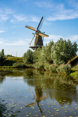 Flour windmill  'Nooit gedagt' on the waterfront of the fortified town of Woudrichem in summer in the Netherlands