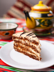  dessert chocolate cake with beige cream in oriental style on a rooftop with a teapot and a cup for tea.