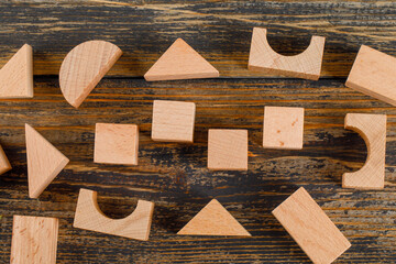 Business concept with wooden geometric shapes on wooden background flat lay.