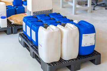 Big blue and white plastic barrels on pallets