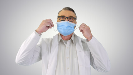 Male Doctor taking off protective Medical mask and smiling to ca