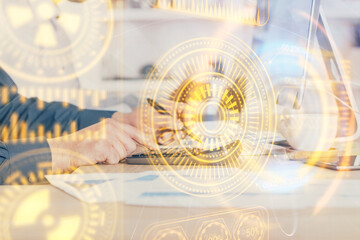 Technology theme hologram with man working on computer on background. High tech concept. Multi exposure.