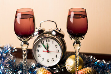 New Year card with glasses, garland, Christmas decorations and alarm clock