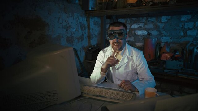 A computer nerd in an old garage has a videoconference. Funny programmer with a mustache and stupid glasses. Virtual, distance learning, teamwork from home office. Retro vintage concept