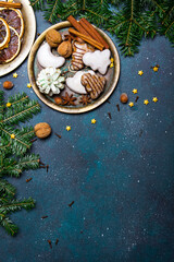 Obraz na płótnie Canvas Beautiful Christmas background with decorations. Christmas cookies witch chocolate, gingerbread cookies, nuts and fir twigs on dark background. Copy space for your text