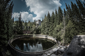 Abandoned water reservoir ruins in forest