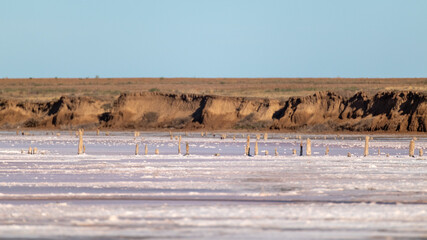 Salt pink lake surface with brown hills coast under blue sunny sky. Spa healthcare natural beauty in Ukraine, Henichesk
