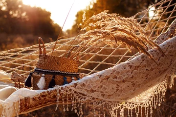 Zelfklevend Fotobehang Boho style, hammock in spikelet background at sunset. Lightness and simplicity.  © Mykola