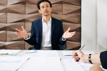 Businesswoman checking financial charts and reports when talking to finance department manager