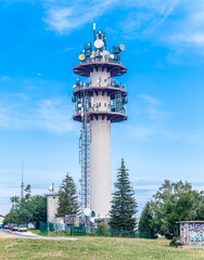 SALEVE, FRANCE - September 19, 2020: Transmission tower with different antennas against a deep blue sky with beautiful white clouds. Radio du Saleve, France.